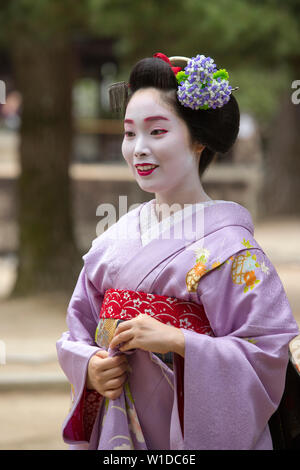 Une Geisha et maiko tirer sur Manpakuji, Kyoto Temple Banque D'Images