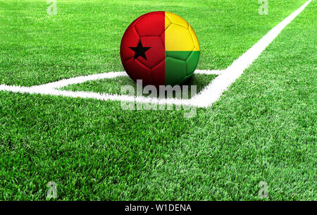 Ballon de soccer sur un terrain vert, drapeau de la Guinée Bissau Banque D'Images