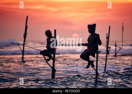 Silhouettes des pêcheurs traditionnels. Pêche à échasses traditionnelles près de Galle au Sri Lanka. Banque D'Images