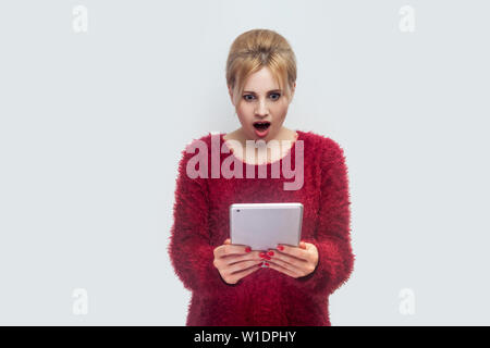 Pas moyen ! Portrait de belle jeune femme incroyable chemisier rouge dans l'article et regarder la vidéo suprised sur sa tablette avec visage choqué. Piscine, iso Banque D'Images