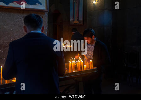 Bougies d'éclairage les gens dans l'Eglise apostolique arménienne Saint Gayane en Vagashpat, Arménie. Banque D'Images