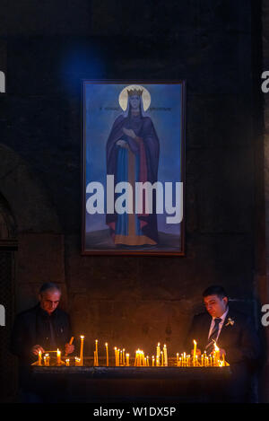 Bougies d'éclairage les gens dans l'Eglise apostolique arménienne Saint Gayane en Vagashpat, Arménie. Banque D'Images