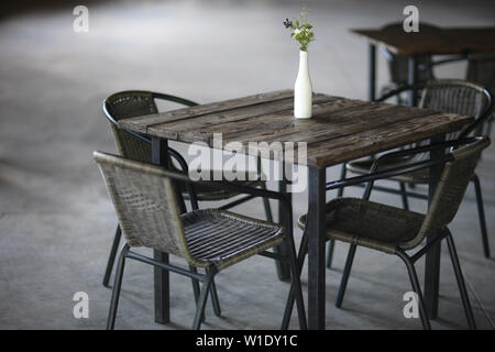 Vert lumineux bouquet de fleurs sauvages dans un vase stylisé-bouteille sur la table d'un café. Banque D'Images