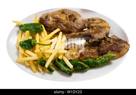 Côtelettes d'agneau savoureux cuit servi avec pommes de terre et le poivron vert à la plaque. Plus isolé sur fond blanc Banque D'Images