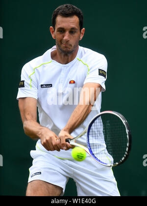 James Ward en action contre Nikoloz Basilashvili le deuxième jour de la Wimbledon à l'All England Lawn Tennis et croquet Club, Wimbledon. Banque D'Images