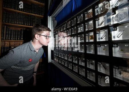 Exposition de la Société Royale des Sciences d'été, un jeune homme regardant un tableau périodique des éléments chimiques, en célébration du 150e anniversaire à Londres. Banque D'Images