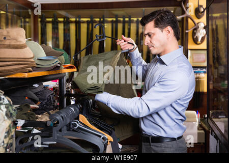 Portrait d'un homme gai chasse choisir ensemble en boutique Banque D'Images