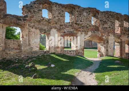 D'anciennes ruines d'un château fort à Dobele. Vue d'ensemble de la cour et ses environs à travers des ouvertures de fenêtres dans le mur. Dobele, la Lettonie. Banque D'Images