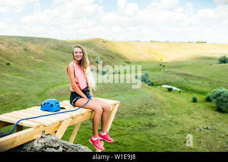 Femme assise sur un rebord en bois sur une haute montagne et vue sur le paysage de montagne. Banque D'Images
