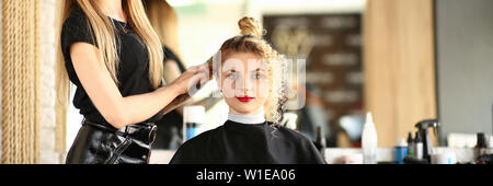 Coiffure mains tiennent fer à friser et faire Banque D'Images