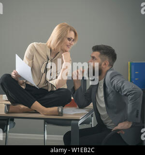 Smiling couple de jeunes collègues qui travaillent dans un bureau moderne. Deux collègues discuter travail, travailler avec des documents. Banque D'Images