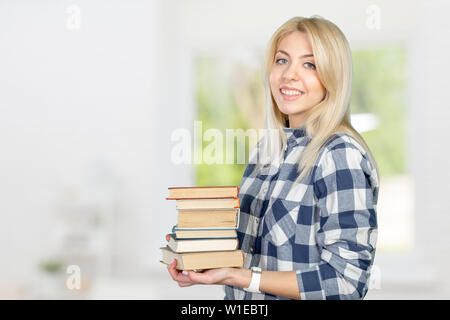 Belle jeune femme holding books Banque D'Images