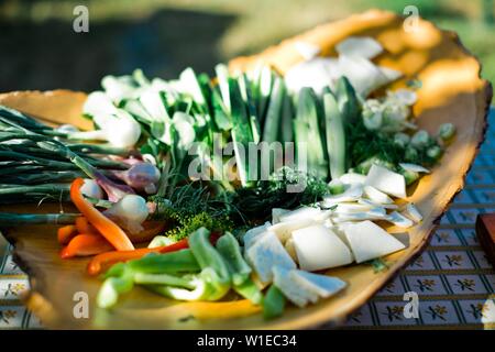 Légumes frais sur la plaque en bois avec des tranches de produits sains Banque D'Images