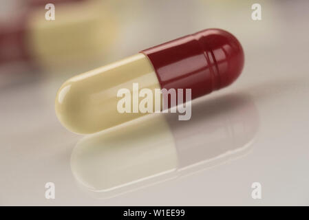 La pénicilline antibiotique capsules répandus sur un fond blanc réfléchissant. Banque D'Images