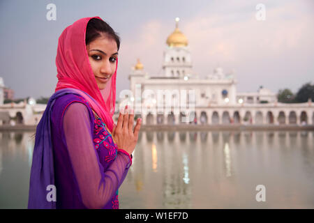Une jeune femme pratiquer leur culte dans un temple sikh à New Delhi, Inde, Asie Banque D'Images