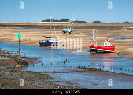 Bateaux colorés sur les bancs de sable à marée basse, les marins de la flotte et de l'estuaire de la rivière, puits à côté de la mer, côte nord du comté de Norfolk, Norfolk, East Anglia, Angleterre, RU Banque D'Images