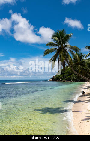 Un couple en train de marcher le long de l'Anse Parnel sur la côte sud-est de Mahé, Seychelles, océan Indien, Afrique Banque D'Images