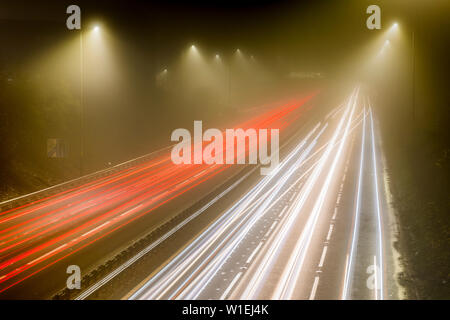 La circulation sur autoroute trail des lumières la nuit, M8, Ecosse, Royaume-Uni, Europe Banque D'Images