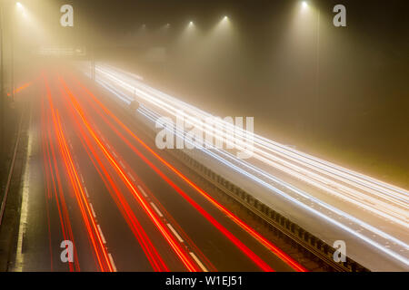 La circulation sur autoroute trail des lumières la nuit, M8, Ecosse, Royaume-Uni, Europe Banque D'Images