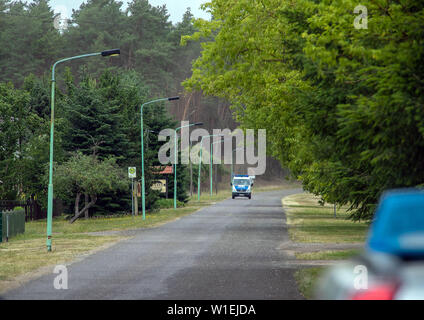 Alt Jabel, Allemagne. 07 juillet, 2019. Une voiture de police est la conduite par les évacués du site. Les task forces tentent d'empêcher l'incendie de forêt sur l'ancienne zone d'entraînement militaire de se propager dans les villages environnants. En raison de l'incendie à l'ancienne zone d'entraînement militaire près de Lübtheen dans Mecklenburg-Vorpommern, des centaines de personnes ont dû quitter leurs foyers. Credit : Jens Büttner/dpa-Zentralbild/ZB/dpa/Alamy Live News Banque D'Images