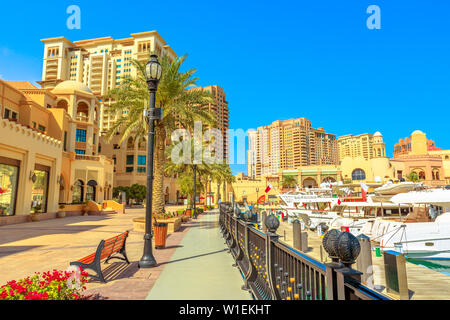 Promenade en corniche Marina Porto Saoudite au Pearl-Qatar, avec tours résidentielles et les bateaux et yachts de luxe dans le golfe Persique, Doha, Qatar Banque D'Images