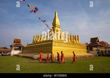 Le stupa bouddhiste d'or de Pha That Luang avec quelques moines bouddhistes ci-dessous, Vientiane, Laos, Indochine, Asie du Sud, Asie Banque D'Images