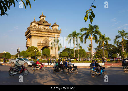 Cyclomoteurs équitation passé Le Patuxai (Victory Monument) Arc de Triomphe de Vientiane, Vientiane, Laos, Indochine, Asie du Sud-Est, l'Asie Banque D'Images