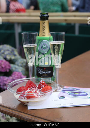 Un bol de fraises et crème avec des verres de champagne et centre court billets le jour deux de la Wimbledon à l'All England Lawn Tennis et croquet Club, Wimbledon. Banque D'Images