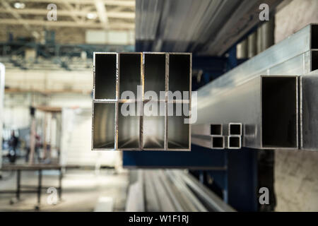 Différentes tailles de tiges empilées dans ancienne usine Banque D'Images