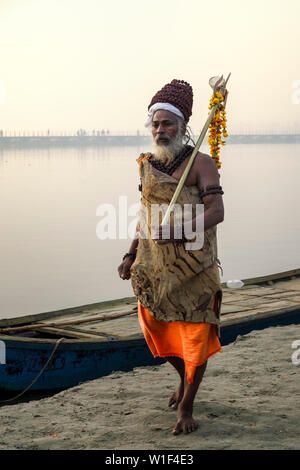 Rome baba avec trident et marigold flower garland sur les rives du Gange au lever du soleil, pour un usage éditorial uniquement, Allahabad Kumbh Mela, World's largest relig Banque D'Images