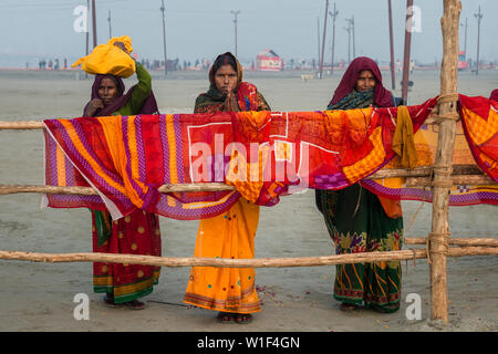 Les femmes indiennes sur les rives du Gange en face de pendaison de couleur rouge-orange, châles, Allahabad Kumbh Mela, le plus grand rassemblement religieux, de l'Uttar Prad Banque D'Images