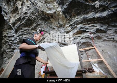 Danzhai, province du Guizhou en Chine. 1er juillet 2019. Une femme de l'ethnie Miao se dessèche en papier Shiqiao Village de Danzhai County, au sud-ouest de la province du Guizhou, en Chine, le 1 juillet, 2019. Shiqiao Village est célèbre pour le patrimoine culturel immatériel national traditionnel de fabrication de papier. Au cours des dernières années, les papetiers ont combiné des techniques traditionnelles avec l'innovation culturelle, faisant de l'art ancien un eye-catcher dans l'industrie du tourisme. Credit : Ou Dongqu/Xinhua/Alamy Live News Banque D'Images