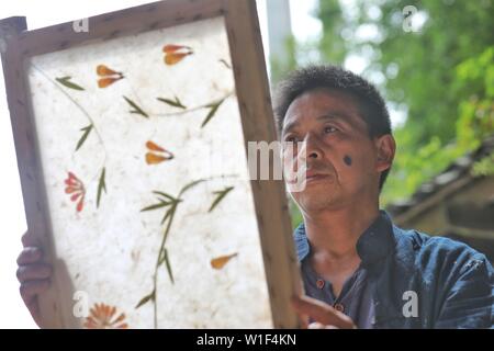 Danzhai, province du Guizhou en Chine. 1er juillet 2019. Un artisan en vérifie le papier fabriqué avec des techniques traditionnelles dans le village de Shiqiao Danzhai County, au sud-ouest de la province du Guizhou, en Chine, le 1 juillet, 2019. Shiqiao Village est célèbre pour le patrimoine culturel immatériel national traditionnel de fabrication de papier. Au cours des dernières années, les papetiers ont combiné des techniques traditionnelles avec l'innovation culturelle, faisant de l'art ancien un eye-catcher dans l'industrie du tourisme. Credit : Ou Dongqu/Xinhua/Alamy Live News Banque D'Images