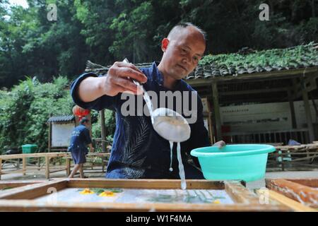 Danzhai, province du Guizhou en Chine. 1er juillet 2019. Un artisan en rend le papier avec des techniques traditionnelles dans le village de Shiqiao Danzhai County, au sud-ouest de la province du Guizhou, en Chine, le 1 juillet, 2019. Shiqiao Village est célèbre pour le patrimoine culturel immatériel national traditionnel de fabrication de papier. Au cours des dernières années, les papetiers ont combiné des techniques traditionnelles avec l'innovation culturelle, faisant de l'art ancien un eye-catcher dans l'industrie du tourisme. Credit : Ou Dongqu/Xinhua/Alamy Live News Banque D'Images