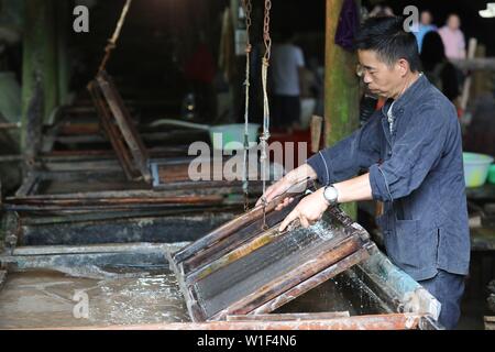 Danzhai, province du Guizhou en Chine. 1er juillet 2019. Un artisan en rend le papier avec des techniques traditionnelles dans le village de Shiqiao Danzhai County, au sud-ouest de la province du Guizhou, en Chine, le 1 juillet, 2019. Shiqiao Village est célèbre pour le patrimoine culturel immatériel national traditionnel de fabrication de papier. Au cours des dernières années, les papetiers ont combiné des techniques traditionnelles avec l'innovation culturelle, faisant de l'art ancien un eye-catcher dans l'industrie du tourisme. Credit : Ou Dongqu/Xinhua/Alamy Live News Banque D'Images