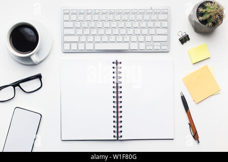 Table de bureau avec Ouvrez le bloc-notes et d'autres accessoires sur blanc Banque D'Images