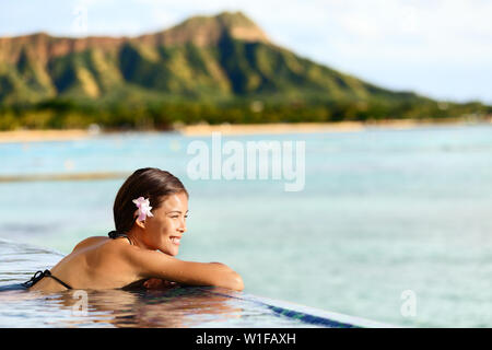 Hawaii beach travel vacation woman swimming relaxant à la piscine de luxe Hôtel resort. Jeunes adultes asiatiques sur la plage de Waikiki, Honolulu, Oahu sur vacances exotiques Banque D'Images