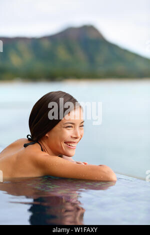 Maison de vacances piscine plage femme à sur Hawaii. Jeune femme chinoise asiatique en relaxant piscine à débordement en hôtel de luxe resort sur la plage de Waikiki à Honolulu, Oahu, Hawaii, USA. Banque D'Images