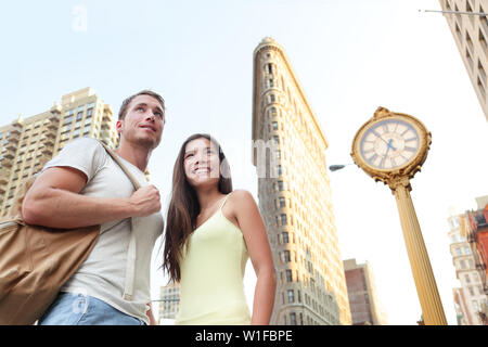 Paris Tourisme - les touristes en visite à New York face à Flatiron building. Jeune couple de touristes dans la ville de New York à la recherche de bâtiments célèbres en été. Banque D'Images