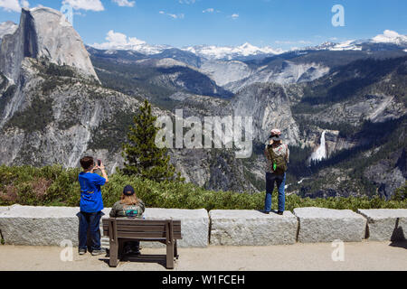 Touristes prenant des photos avec mobile de l'automne Nevada, demi-dôme et vallée de Yosemite de Glacier point dans le parc national de Yosemite, Californie Banque D'Images