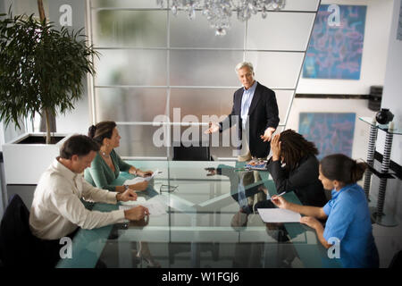 Mature businessman de parler à des collègues dans une salle de réunion. Banque D'Images