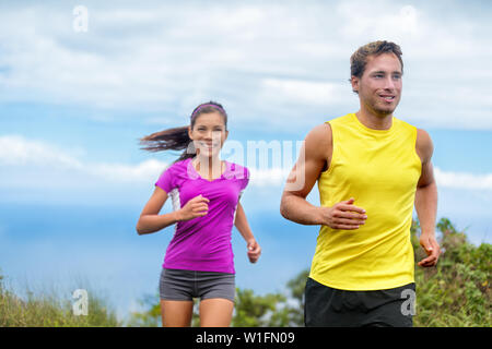 Les sportifs trail running en bonne santé vivant une vie active. Vie de couple heureux les athlètes qui s'entraînent ensemble cardio plein air en été. Groupe multiethnique Asian woman with handsome fit man formateur. Banque D'Images