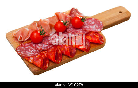 Charcuterie appétissant de jambon espagnol et épicée saucisses sèches avec tomates cerise sur planche de bois. Plus isolé sur fond blanc Banque D'Images