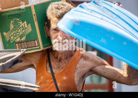 La Havane, Cuba - 17 mai 2019 : dirty old Cuban sans-abri est à la recherche dans les poubelles dans les rues de la vieille ville de La Havane pendant une chaude journée ensoleillée. Banque D'Images