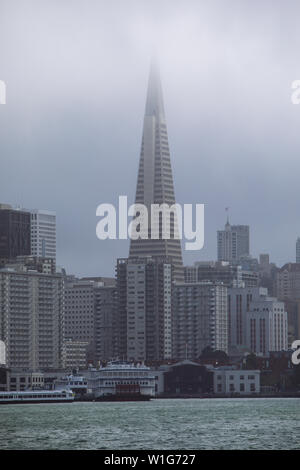 Téléobjectif du Transamerica Pyramid Building dans le quartier financier parmi la brume à San Francisco depuis le ferry dans la baie, Californie, Etats-Unis Banque D'Images