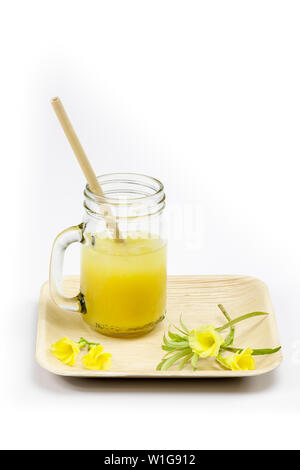 Eco-friendly Bamboo paille avec du jus d'orange contre fond blanc (pas de notion de plastique) Banque D'Images