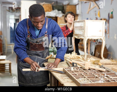 La femme et l'homme les charpentiers à l'aide d'outils en bois restauration de bureau en studio Banque D'Images