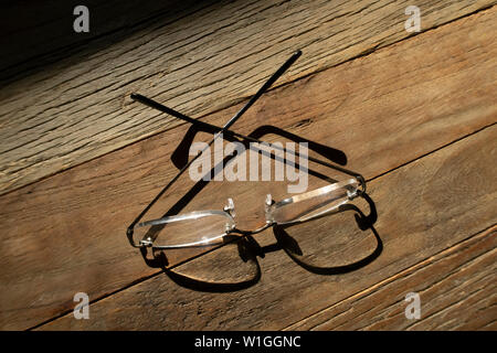 Les lunettes replié sur une table en bois Banque D'Images