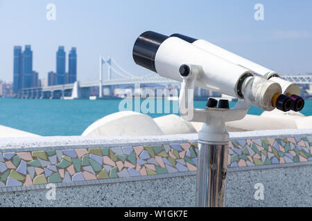 Télescope binoculaire sur une base rotative montée sur un point de vue touristique de plein air avec paysage ville Busan floue sur un arrière-plan. République de Corée Banque D'Images