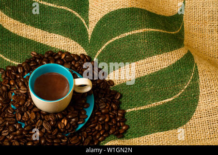 Tasse d'expresso avec des haricots et de la toile à l'arrière-plan Banque D'Images